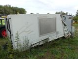 a white trailer that has been flipped over in the grass