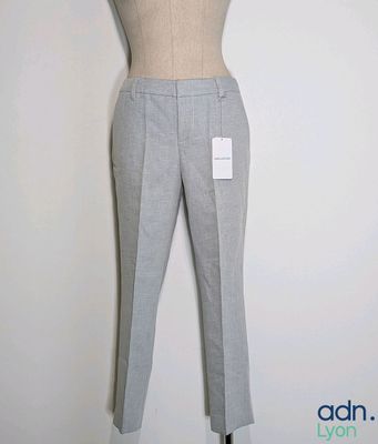 grey pants on a mannequin stand against a white wall