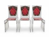 une paire de chaises transparentes ornées de motifs rouges et dorés