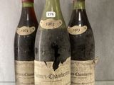 three bottles of wine sitting on top of a glass shelf