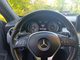 the steering wheel of a mercedes car with a yellow and black steering rope