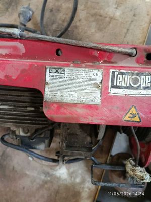 a red motorbike that is sitting in the garage