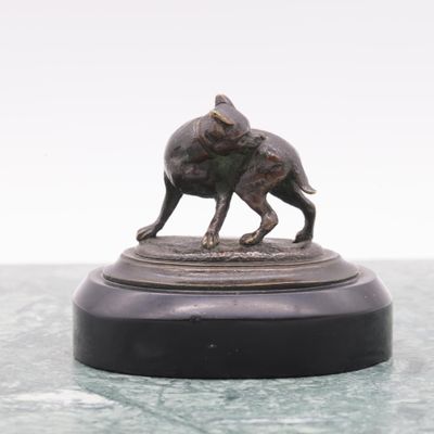 a bronze statue of a dog and a cat on a pedestal