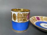 pair of blue and white cups with gold rims on a table