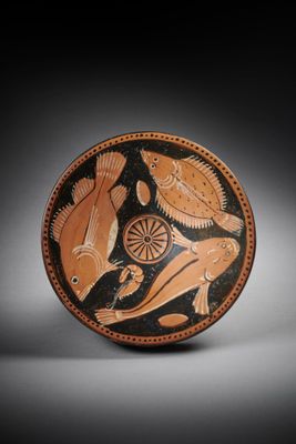 a black and orange plate with a bird and fish on it