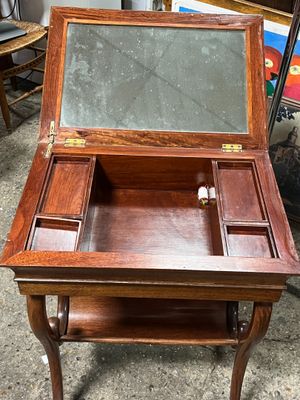 une petite table en bois sur laquelle se trouve un miroir