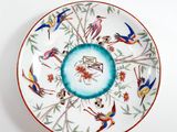 a colorful plate with birds and flowers on it