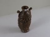 a brown vase sitting on a table with a white background