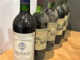 plusieurs bouteilles de vin sont alignées sur une table en bois