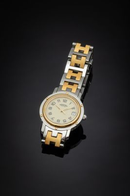 a silver and gold watch on a black surface