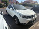 Le SUV Nissan blanc est garé sur le bord de la route.