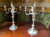 two silver candelabs sitting on a wooden table