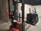 un chariot élévateur à fourche dans un bâtiment dont la porte est verte