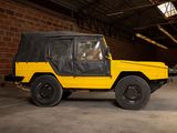 a yellow jeep with a black cover parked in a garage