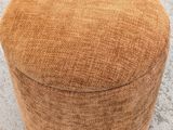 a close up of a round ottoman sitting on a concrete floor