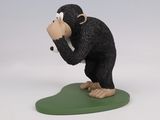 figurine of a monkey on a green base with a white background