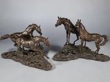 deux sculptures en bronze représentant des chevaux au galop sur un sol rocheux