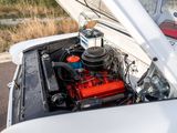 a white car with a red engine in the back of it