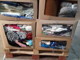 a carton filled with lots of clothes on top of a pallet