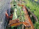 un tracteur qui se trouve dans l'herbe derrière une clôture