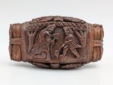 an antique carved wooden bracelet with a scene of a man and woman in a forest