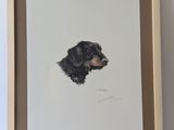 painting of a black dog in a wooden frame on a white wall