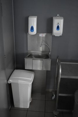 une petite salle de bains équipée d'un lavabo, de toilettes et d'une poubelle