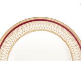 a white plate with a gold rim and a red border