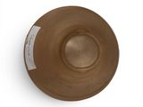 a brown bowl on a white surface with a sticker on it