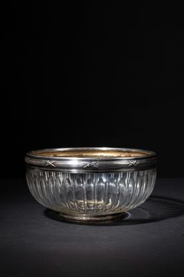 a glass bowl with a gold rim on a black surface