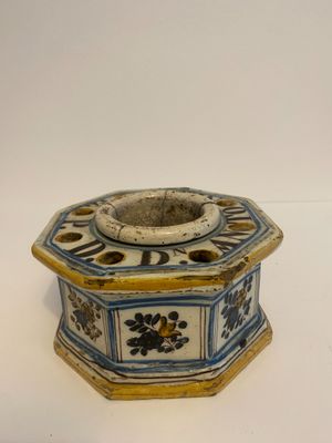 a small blue and white candle holder on a white surface