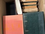 books in a box on a table with a phone in it