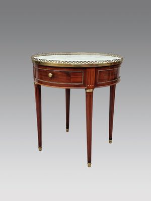 une petite table ronde avec un plateau en marbre