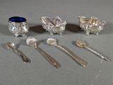 five silver spoons and two silver cups and spoons on the table