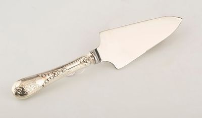 a silver plated cheese knife with a handle and a handle