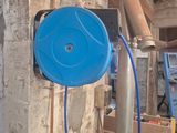 un tuyau bleu fixé à un poteau métallique dans une pièce