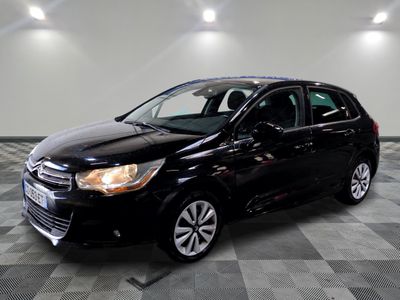 a black car is parked in a large room with a checkered floor