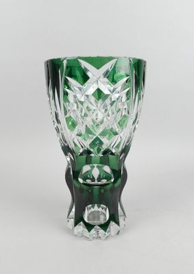 vase en verre vert posé sur une surface blanche, avec un fond blanc