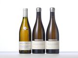 three bottles of wine are lined up on a table