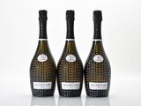 trois bouteilles de champagne posées les unes à côté des autres sur une surface blanche