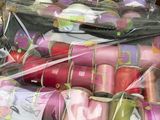 de nombreux rouleaux de tissu emballés dans des sacs en plastique, posés sur une table