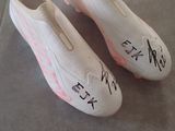 une paire de chaussures avec des inscriptions dessus, posée par terre