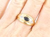 an image of a woman ' s hand holding a ring with a sapphire stone in it