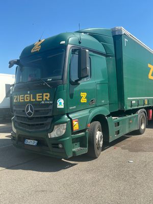 a green truck that is parked in a parking lot