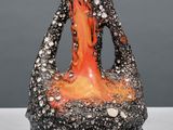 a black and orange vase sitting on a table