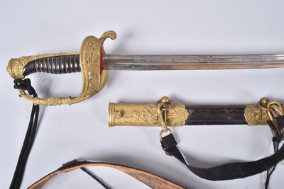 une épée avec une poignée en or sur une surface blanche