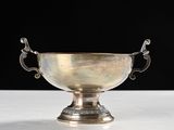 an antique silver plated bowl with handles on a white table