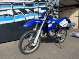a blue dirt bike parked in front of a building