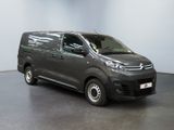 the grey van is parked in a large room with a black floor