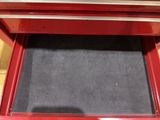 a red tool box with a black mat in it